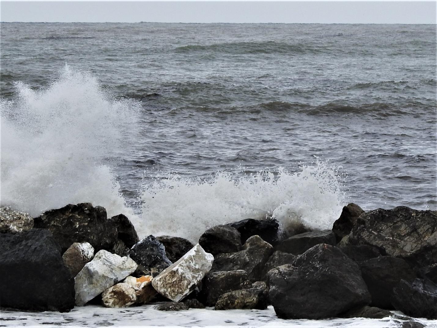 A rocky beach next to the oceanDescription generated with very high confidence