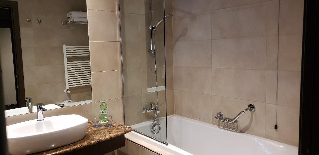 A bathroom with a sink and a mirrorDescription automatically generated
