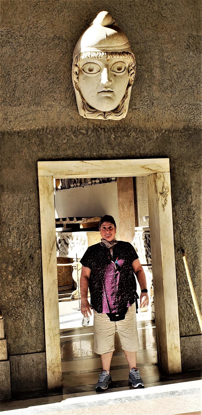 A person standing in front of a carved wood statueDescription automatically generated with low confidence