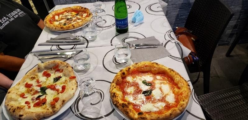 A couple of pizzas on a tableDescription automatically generated with medium confidence