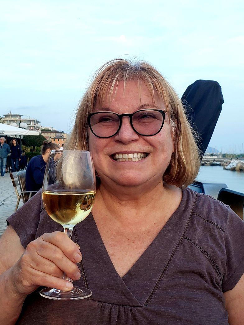 A person holding a glass of wineDescription automatically generated with medium confidence