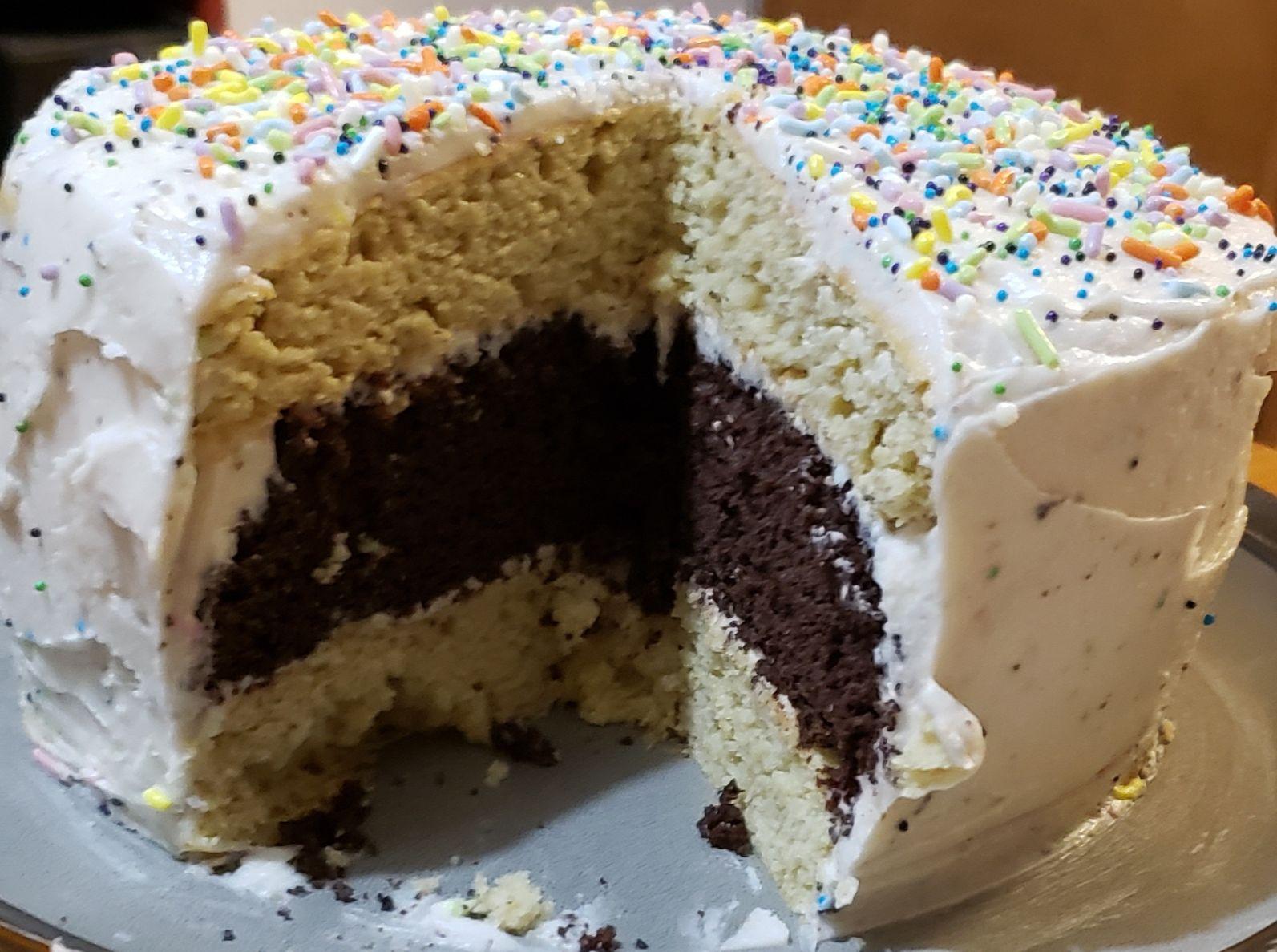 A cake with frosting and sprinkles on itDescription automatically generated with medium confidence