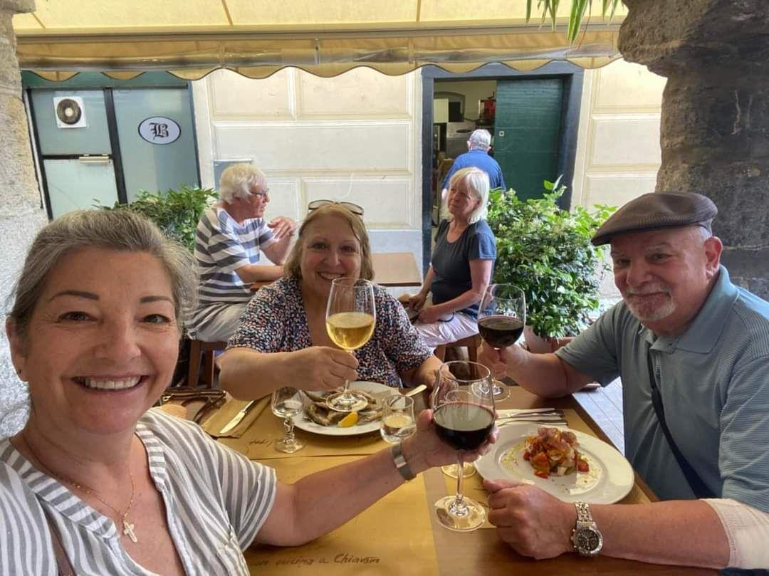 A group of people sitting at a table with food and drinksDescription automatically generated with medium confidence
