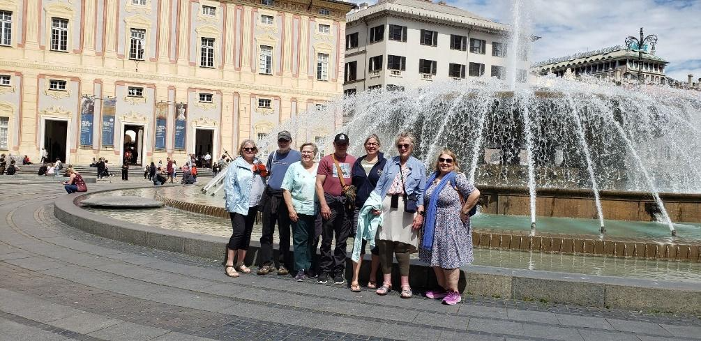 A group of people posing for a photo in front of a fountainDescription automatically generated