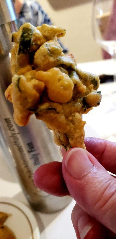 A hand holding a fried foodDescription automatically generated with low confidence