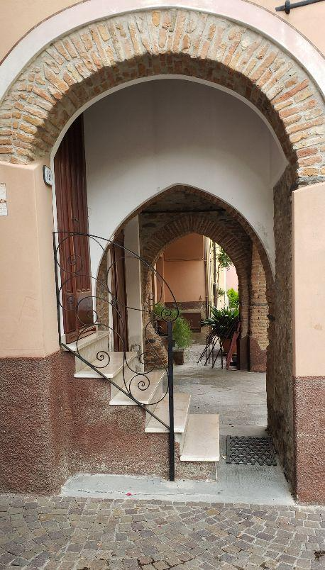 A picture containing building, outdoor, door, archDescription automatically generated