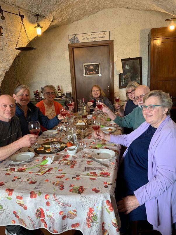 A group of people sitting at a table with wine glassesDescription automatically generated with medium confidence