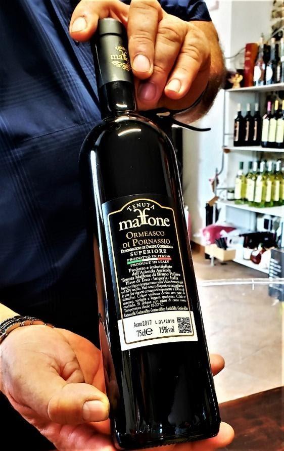 A person holding a bottle of wineDescription automatically generated