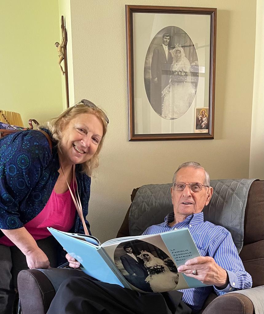 A person and person sitting on a couch reading a bookDescription automatically generated