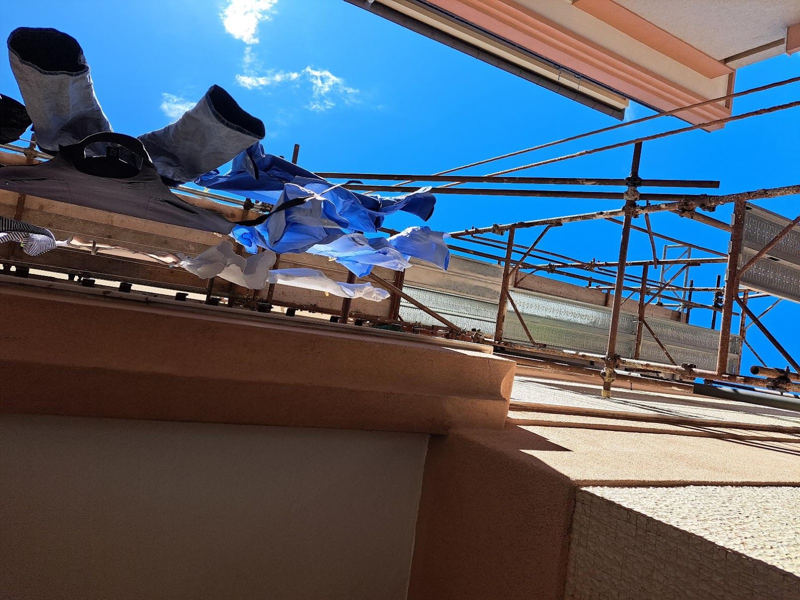 A scaffolding with clothes from itDescription automatically generated