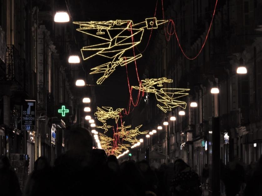 A street with lights and people walkingAI-generated content may be incorrect.