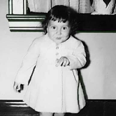 A baby in a white dressAI-generated content may be incorrect.