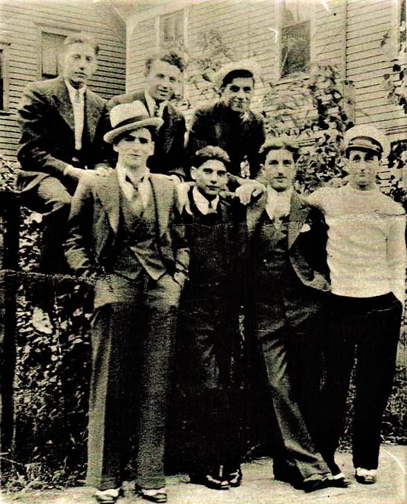A vintage photo of a group of people posing for the camera

Description generated with very high confidence
