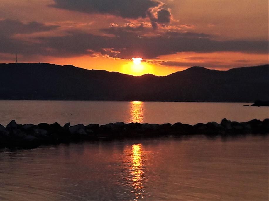 A sunset over a body of water

Description generated with very high confidence